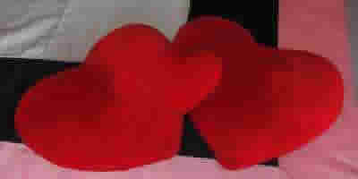 Tres cojines de corazones rojos.