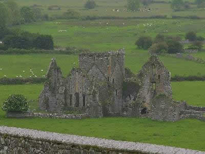 Piccolo castello in rovina nel mezzo del campo verde.